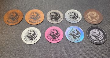 Nine colorful Takuache Club tokens with a fierce animal logo.