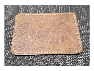 A rectangular piece of brown leather with stitching around the edges.